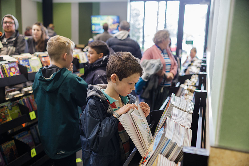 Image of Searching through books at the opening of the new Library Saturday, 22 July 2017