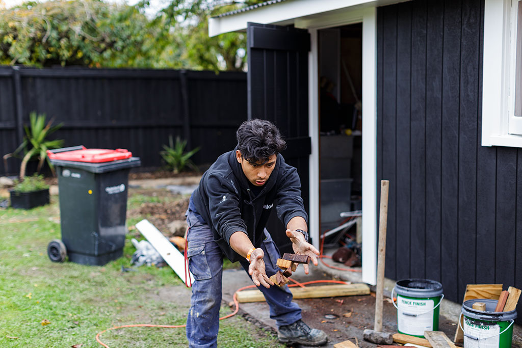 Image of Arjun, a local builder, cleans up the backyard of a house Thursday, 4 May 2017