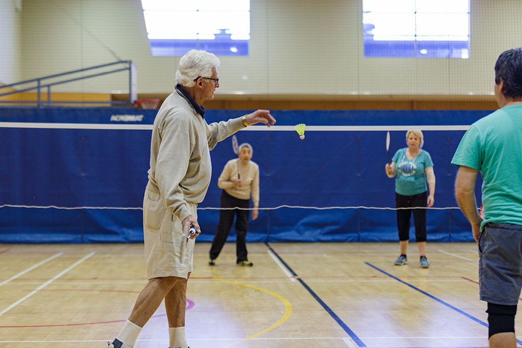 Image of A member of the social Badminton Club serves the shuttlecock at the beginning of a match Tuesday, 18 July 2017