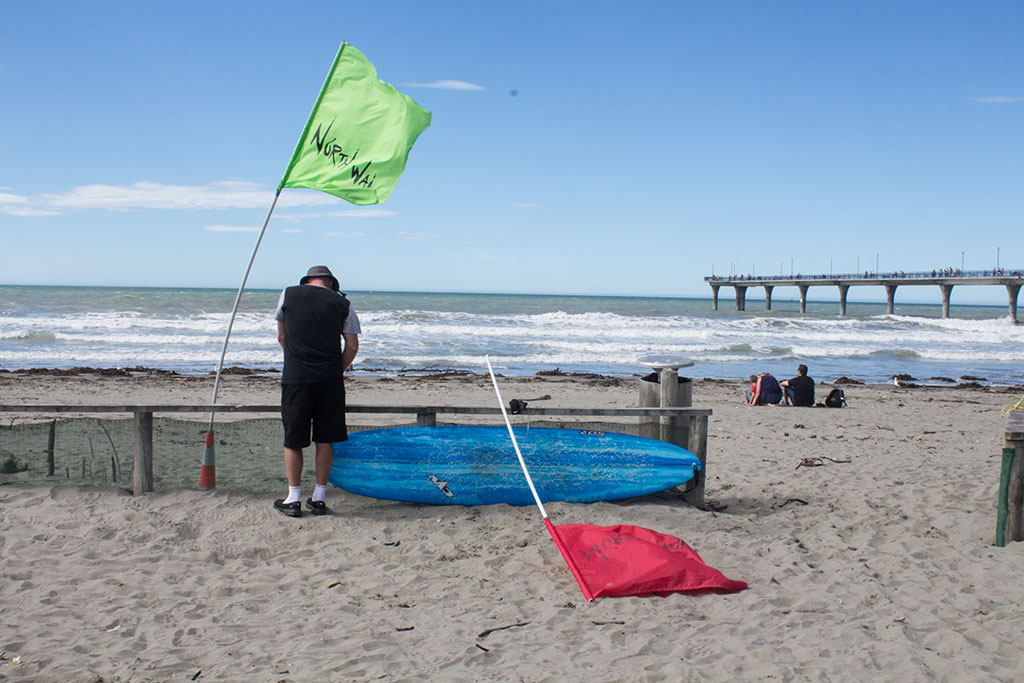 Image of Flag man at a local surfing competition, New Brighton. Saturday, 19 March 2016
