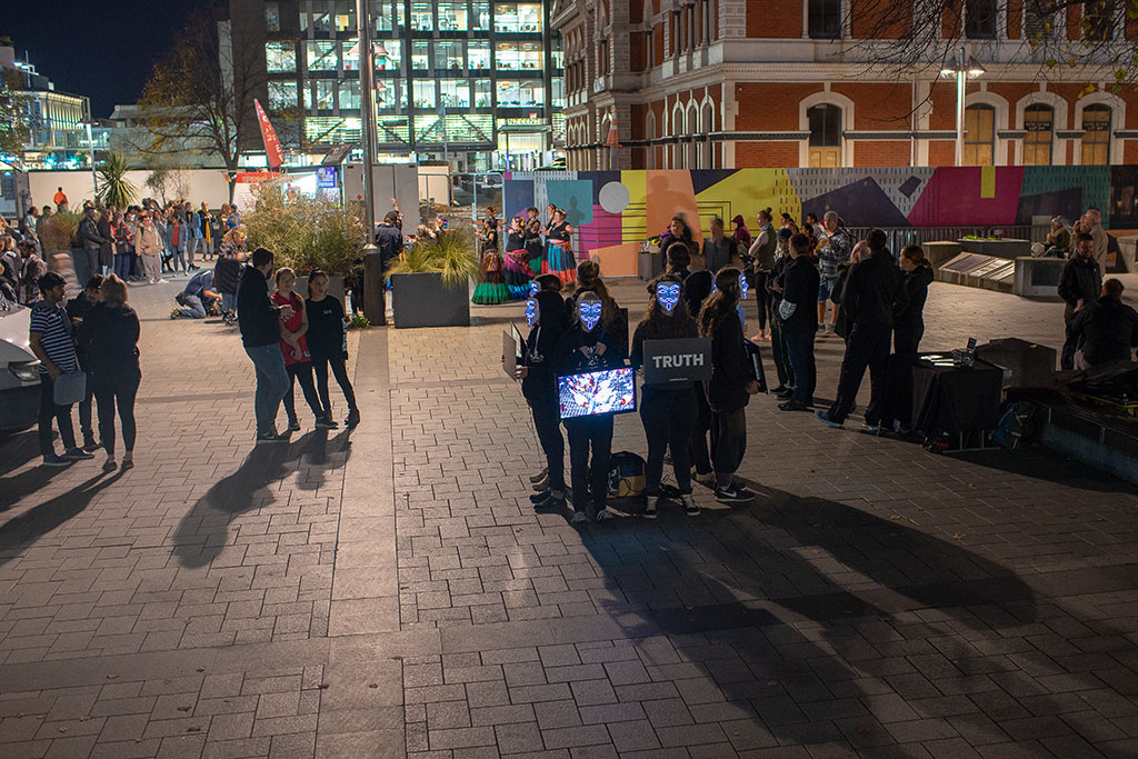 Image of Friday night market patrons watching Anonymous For The Voiceless protest, and the belly dancers, Cathedral Square. Friday, 27 April 2018