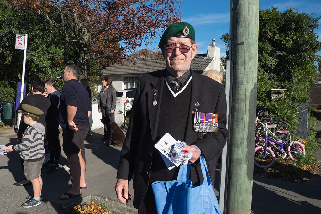 Image of Man hands out Anzac ribbons to children at the Anzac Day parade, 322 Halswell Road. 25-04-15 9.25 a.m.