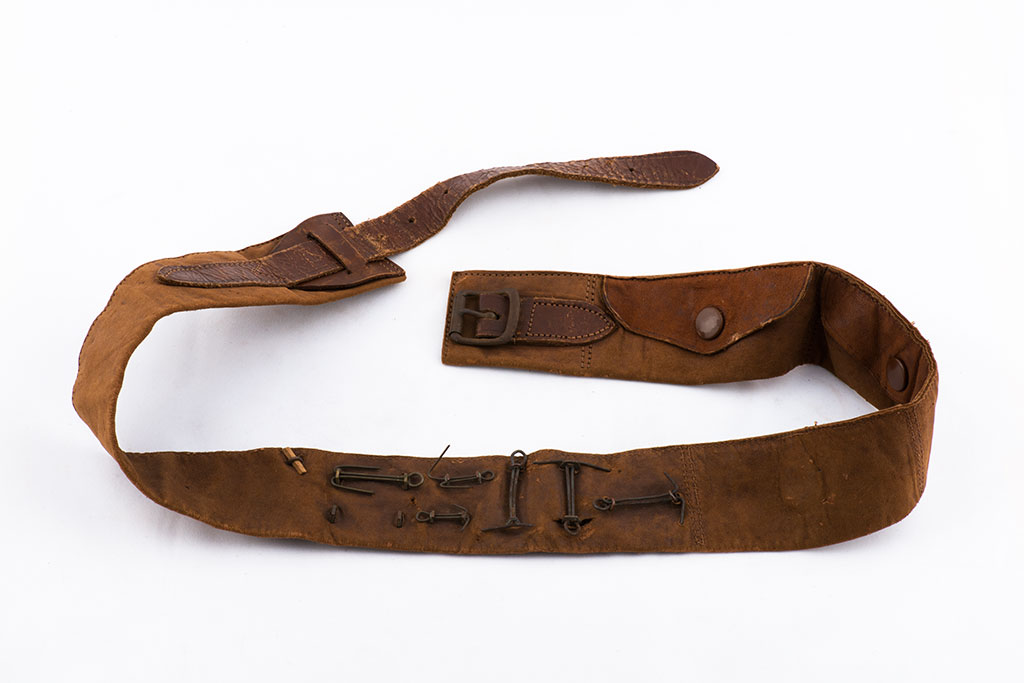 Image of Back of Leather money belt showing attachments of added badges and button ca. 1917