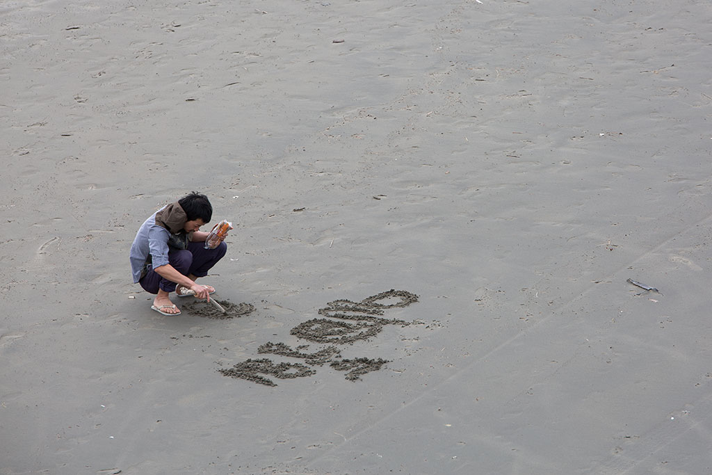 Image of Man writes in sand. 04-10-2015 3:40 p.m.