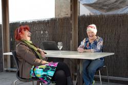 Thumbnail Image of Marta and Charmaine enjoy a drink after a day's work at the Saturday Seaside Market