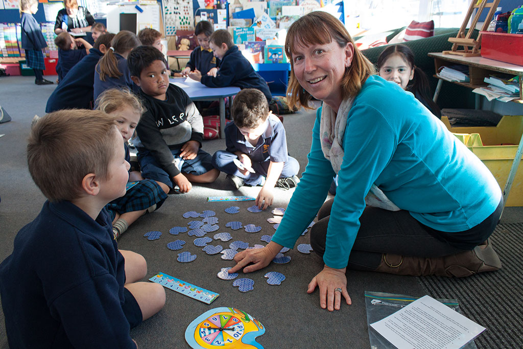 Image of A teacher aide helps out in the classroom, South New Brighton School. Thursday, 28 July 2016