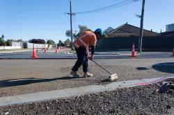Thumbnail Image of A worker sweeps gravel, Bower Avenue, New Brighton