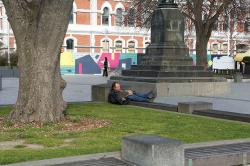 Thumbnail Image of A man sleeping in the square at lunchtime, Cathedral Square