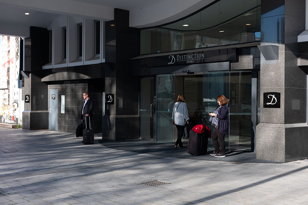 Image of Travellers outside the Distinction Christchurch Hotel, 14 Cathedral Square. Tuesday, 17 July 2018