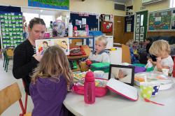 Thumbnail Image of Mel (student teacher) reads to Austin, Abby and another child at Kidsfirst Kindergarten